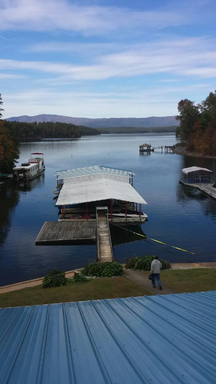 View across a lake from a newly installed blue metal roof in Lyons